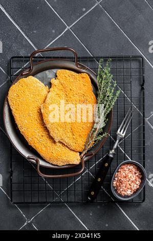 Weiner Schnitzel allemand, cru et fait maison. Arrière-plan noir. Vue de dessus. Banque D'Images