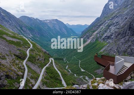 Une route sinueuse serpente à travers les montagnes norvégiennes verdoyantes, avec une vue panoramique offrant une vue imprenable sur la vallée en contrebas. Trollstigen Road Norvège Banque D'Images