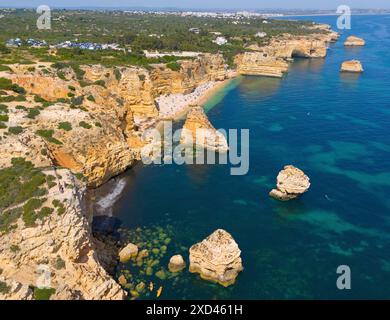 Falaises abruptes et eaux bleues claires le long de la côte impressionnante avec de petites plages et des formations rocheuses, vue aérienne, Praia da Marinha, Lagoa Banque D'Images