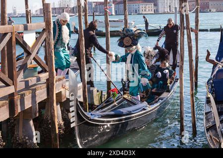 Personnes en costumes historiques débarquant d'une gondole pendant le Carnaval de Venise, Venise, Italie Banque D'Images