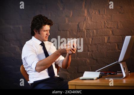 Bureau, enquête et tablette avec l'homme détective dans le bureau la nuit pour travailler sur le rapport criminel. Mur de briques, informations et ordinateur portable avec mature Banque D'Images