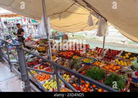 Vendeur vendant des produits frais sur un bateau de marché dans un canal au large de la via Garibaldi, Castello, Venise Banque D'Images