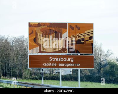 Strasbourg, France - 20 mars 2024 : panneau d'affichage de bienvenue présentant Strasbourg comme capitale européenne avec des représentations artistiques des institutions de l'Union européenne - vue depuis l'autoroute - signalisation pour le Conseil de l'Europe et le Parlement européen Banque D'Images