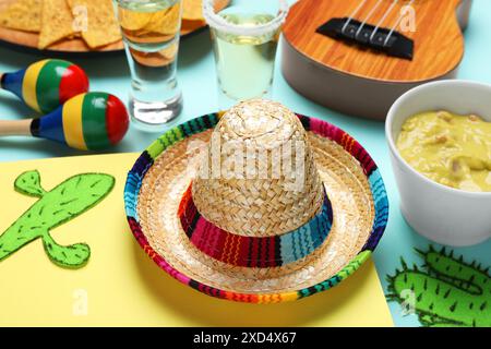 Chapeau sombrero mexicain, guacamole, maracas, cactus en papier et tequila sur fond de couleur Banque D'Images