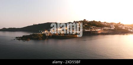 Paysage aérien du pittoresque village de pêcheurs de Cornouailles de Coverack en Cornouailles avec des maisons de vacances souhaitables et des chalets coûteux surplombant la mer Banque D'Images