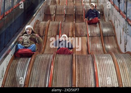 Toboggans classiques dans un parc d'attractions. Les enfants s'amusent à glisser vers le bas d'une toboggan Banque D'Images