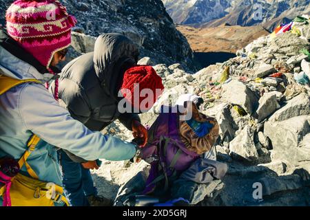 Guide professionnel népalais utiliser le moniteur de doigt d'oxygène pour vérifier les niveaux d'oxygène du sang de trekker femme. Himalaya haute altitude sensation de faible niveau d'oxygène aff Banque D'Images