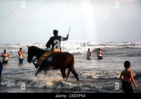 Les personnels de police patrouillant à cheval et dispersant les gens visitent Sea View Beach alors que l'interdiction a été imposée de se baigner dans la mer en raison des conditions difficiles de la mer, dans la zone de Clifton à Karachi le jeudi 20 juin 2024. Banque D'Images