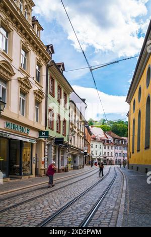 Freiburg im Breisgau, Allemagne, 23 juillet 2023, pistes de tramway dans les rues pavées étroites de la vieille ville, maisons colorées et les gens visitant la ville Banque D'Images