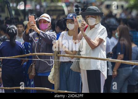 Chiang mai, Thaïlande. 20 juin 2024. Les visiteurs prennent des photos pendant le festival. Le festival est unique et peu fréquenté par des étrangers, mais a lieu chaque année dans les contreforts de la montagne Doi Kham, pour rendre hommage à deux anciens esprits géants, pu SAE et ya SAE. (Photo de Pongmanat Tasiri/SOPA images/Sipa USA) crédit : Sipa USA/Alamy Live News Banque D'Images