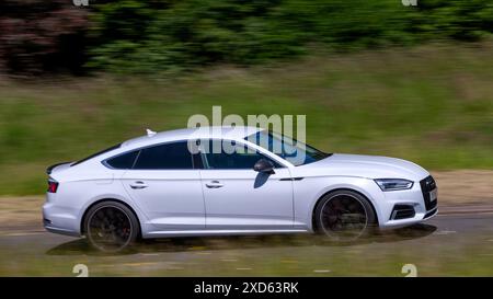 Milton Keynes, Royaume-Uni - 20 juin 2024 : 2017 voiture Audi A5 blanche conduisant sur une route de campagne britannique Banque D'Images