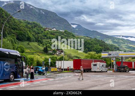 Voyageurs à une station-service ENI sur l'autoroute A22 dans le Sudtirol, entourée de collines verdoyantes et de montagnes pittoresques. Banque D'Images