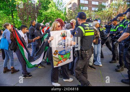 La Haye, pays-Bas. 19 juin 2024. Des manifestants pro-palestiniens tentent de percer la ligne tampon de la police, pendant la manifestation. Une petite manifestation, mais très vive, à la Haye pour attirer l'attention sur le sort des Palestiniens déplacés en Europe et dans le monde en général en raison de la guerre génocidaire d'Israël contre Gaza. Crédit : SOPA images Limited/Alamy Live News Banque D'Images