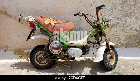 Vieux, tatty mini moto garé dans la rue, Megalo Chorio village, île de Tilos, Dodécanèse, Grèce. Prise en mai 2024 Banque D'Images