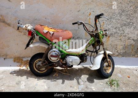 Vieux, tatty mini moto garé dans la rue, Megalo Chorio village, île de Tilos, Dodécanèse, Grèce. Prise en mai 2024 Banque D'Images