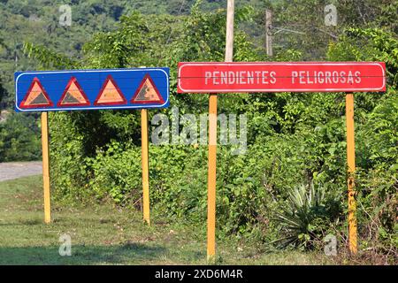 416 panneau de signalisation indiquant des ''pendientes peligrosas-grades dangereux'' sur la route passant devant le village de Santo Domingo, en descendant la rivière Yara. Granma-Cuba. Banque D'Images