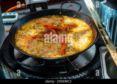 Processus de cuisson de paella de fruits de mer dans une grande poêle à frire Banque D'Images