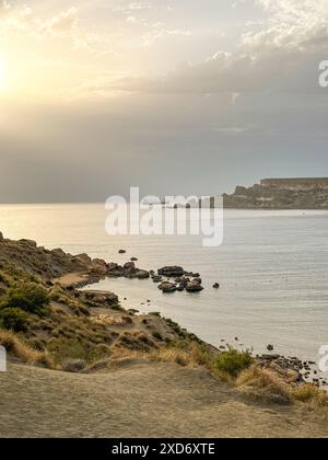 Baie de Ghajn tuffieha au coucher du soleil. Station tropicale. Mer maltaise. Paysage panoramique avec plage Banque D'Images
