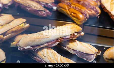 Sandwichs bocadillo de baguette avec jamon derrière le verre d'affichage Banque D'Images