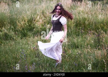 Cracovie, Pologne. 20 juin 2024. Une fille célèbre le solstice d'été pendant la 'nuit de Kupala' près de la butte de Cracovie, Pologne, le 20 juin 2024. Le KupaÅ‚une nuit est la fête des vieux slaves tombant sur la nuit la plus courte de l'année. Au cours de cette nuit, des rituels ont été exécutés tels que la cueillette et la fabrication de couronnes à partir d'herbes et de fleurs sauvages par des filles et des jeunes femmes, l'envoi de guirlandes sur l'eau, l'allumage de feux, la danse, le chant et le saut par-dessus le feu. (Crédit image : © Beata Zawrzel/ZUMA Press Wire) USAGE ÉDITORIAL SEULEMENT! Non destiné à UN USAGE commercial ! Banque D'Images