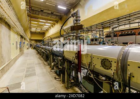 Grand tube métallique d'accélérateur de particules avec tuyaux connectés. Ancien bâtiment de laboratoire physique avec équipement synchrophasotron Banque D'Images