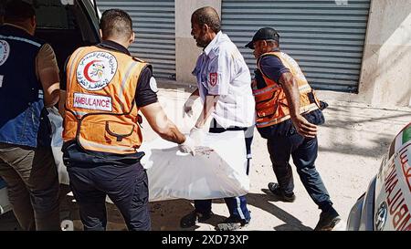 Rafah, Gaza. 20 juin 2024. Le personnel d’urgence palestinien transporte la victime après une frappe aérienne israélienne sur un bâtiment à Rafah, dans le Sud de la bande de Gaza, le 20 juin 2024. Photo de la Défense civile palestinienne/UPI crédit : UPI/Alamy Live News Banque D'Images