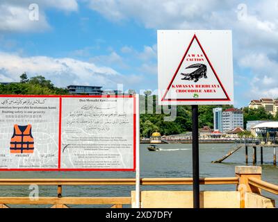 BANDAR Seri BEGAWAN, BRUNEI - 21 AVRIL 2024 : panneau d'avertissement pour se méfier de la zone des crocodiles avant de traverser vers Kampong Ayer, village traditionnel de Banda Banque D'Images