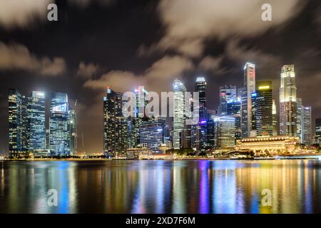 Superbe vue nocturne du centre-ville de Singapour. Gratte-ciel étonnants et autres bâtiments modernes sur fond de ciel sombre. Banque D'Images