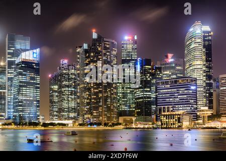 Superbe vue nocturne du centre-ville de Singapour. Gratte-ciel étonnants et autres bâtiments modernes sur fond de ciel sombre. Banque D'Images