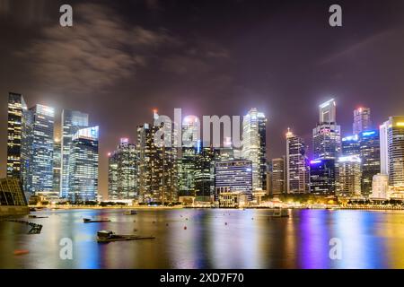 Superbe vue nocturne du centre-ville de Singapour. Gratte-ciel étonnants et autres bâtiments modernes sur fond de ciel sombre. Banque D'Images