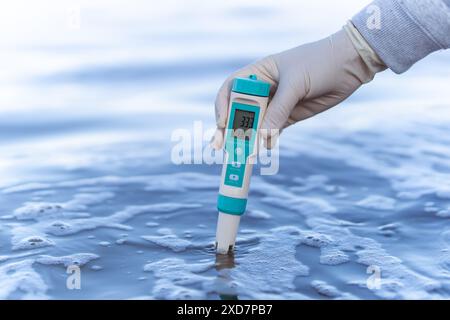 Le technicien utilise l'équipement professionnel d'analyse de l'eau pour mesurer la qualité de l'eau au canal public. Mesure portable de la qualité de l'eau à paramètres multiples Banque D'Images