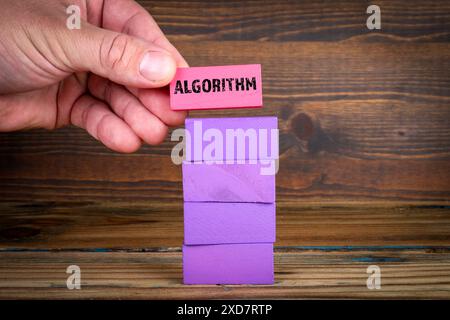 Concept d'algorithme. Blocs violets dans une pile sur un fond de texture en bois. Banque D'Images