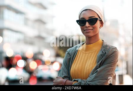 Femme portrait, musulmane et hijab avec des lunettes de soleil en ville pour voyage, tourisme ou week-end. Bokeh, sourire et personne avec les bras croisés pour Banque D'Images