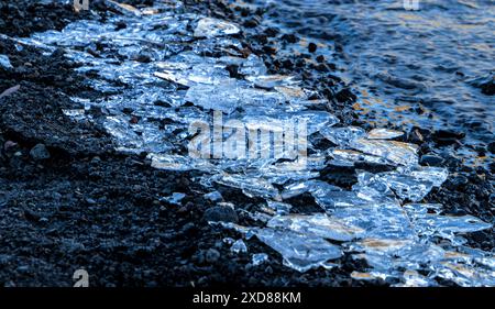 Un gros tas de cristaux de glace cassés sur une plage. La glace fond. La scène est froide et désolée Banque D'Images