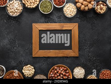 Cacahuète, noisette, noix, amandes, pistache, tournesol, citrouille, chia, noix de pécan et noix de cajou mélangées saines et graines avec menu board. Banque D'Images