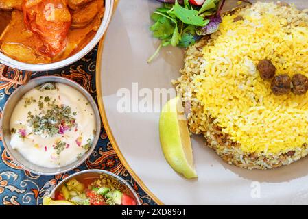 Vue de dessus des plats traditionnels iraniens et des collations. Polow, kufte, salade de légumes frais et yaourt. Cuisine persane impressionnante. Banque D'Images