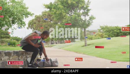 Image des icônes de notification sur l'athlète masculin afro-américain avec la jambe prothétique dans le parc Banque D'Images