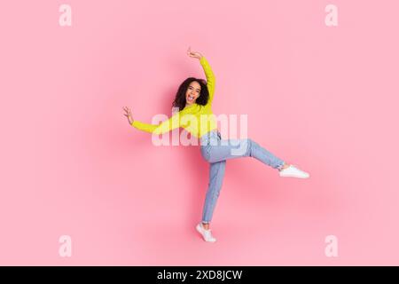 Portrait photo d'adolescente brune cheveux bouclés amusez-vous à danser à la discothèque devenir fou isolé sur fond de couleur rose Banque D'Images