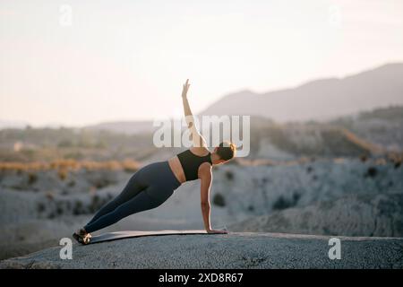 Femme sportive faisant des poses d'asana dans le désert. Banque D'Images