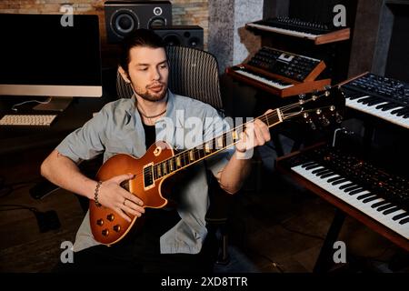 Un homme habile joue de la guitare électrique avec passion dans un studio d'enregistrement lors d'une répétition de groupe de musique. Banque D'Images