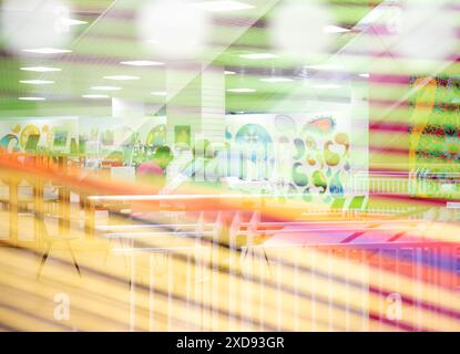 Une image abstraite colorée à travers une fenêtre avec des stores vert jaune et orange au premier plan et une exposition montrant des œuvres basées sur le Paisley Banque D'Images