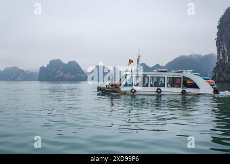 Baie d'Halong, Vietnam - 30 janvier, 2024 : un bateau de tourisme naviguant dans la baie d'Ha long, mer de Chine méridionale Banque D'Images