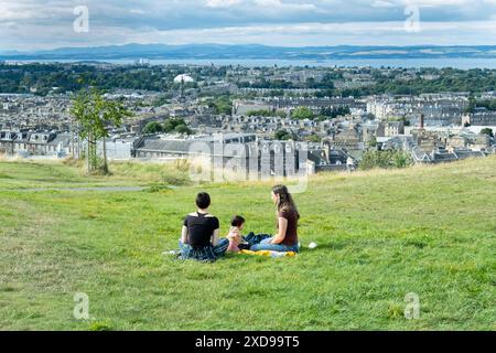 Famille se relaxant sur la colline de calton, en profitant de la vue panoramique sur Edimbourg, en Écosse Banque D'Images