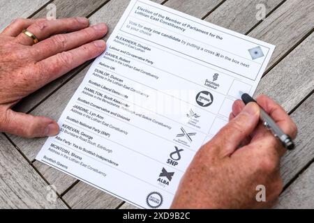 East Lothian, Écosse, Royaume-Uni, 21 juin 2024. Le bulletin de vote postal de l'élection générale arrive : les électeurs sont invités à choisir un candidat parmi 7 candidats pour la nouvelle circonscription réorganisée de Lothian East, dont Douglas Alexander (Labour écossais), Robert Davies (Reform UK), Duncan Dunlop (Liberal Democrats), Scott Hamilton (Parti conservateur), Lyn Jardine (SNP), George Kerevan (Alba) & Shona McIntosh (Parti Vert), crédit : Sally Anderson/Alamy Live News Banque D'Images