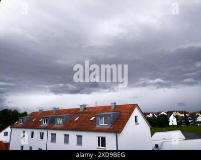 Langweid, Bavière, Allemagne - 21 juin 2024 : orage sur la région d'Augsbourg en Bavière. Des avertissements de violents orages, de foudre et de fortes pluies, ainsi que de grêle ont été émis, des nuages orageux sombres se déplacent vers le haut sur les toits d'un immeuble résidentiel. *** Unwetter über Region Augsbourg dans le Bayern. Warnung vor starkem Gewitter, Blitzschlag und Starkregen, sowie Hagel wurde ausgesprochen, dunkle Gewitterwolken ziehen auf über den Dächern eines Wohnhauses. Banque D'Images