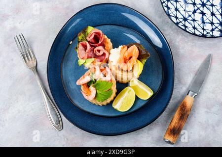 Délicieuses tartelettes au saumon fumé, crevettes et bacon. Banque D'Images