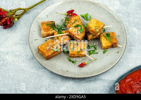 Assiette avec brochettes de fromage tofu grillé. Tofu au fromage rôti dans l'assiette. Banque D'Images