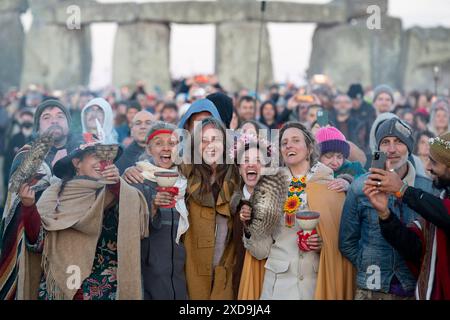 Les fêtards spirituels célèbrent le solstice d'été (mi-été et jour le plus long) sur les anciennes pierres du néolithique tardif de Stonehenge, le 21 juin 2024, dans le Wiltshire, en Angleterre. Le solstice d'été est le jour le plus long de l'hémisphère nord et la nuit la plus courte de l'année, lorsque l'axe de la terre est incliné à son point le plus proche du soleil et les païens disent que l'ancien monument est un lieu sacré qui relie la Terre, la Lune, le Soleil et les saisons. Stonehenge a été construit en trois phases entre 3 000 av. J.-C. et 1 600 av. J.-C. Stonehenge appartient à English Heritage qui dit que 15 000 visiteurs ont été autorisés à entrer dans le Banque D'Images