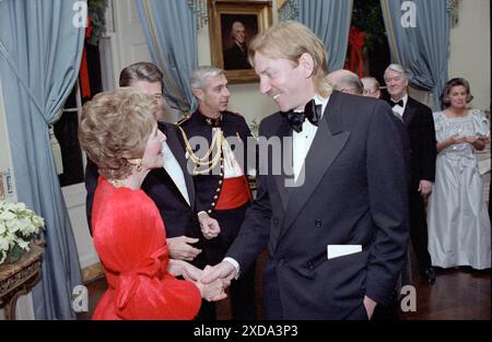 Le président Ronald Reagan et Nancy Reagan accueillent l'acteur Donald Sutherland à la réception des honneurs du Kennedy Center dans la Blue Room de la Maison Blanche, Washington, DC, le 6 décembre 1981. Photo de White House photo Collection. Banque D'Images