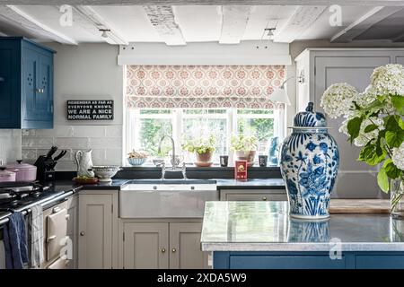 Stores Tasha textiles avec des pots à couvercle bleu et blanc d'OKA dans une cuisine de ferme rénovée du 16ème siècle, Suffolk, Angleterre, Royaume-Uni Banque D'Images